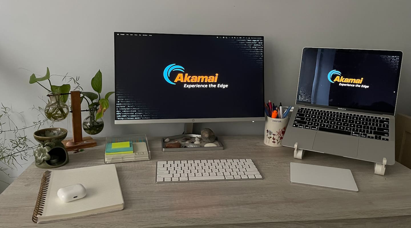 A work-from-home setup including a monitor, laptop stand, trackpad, and keyboard.