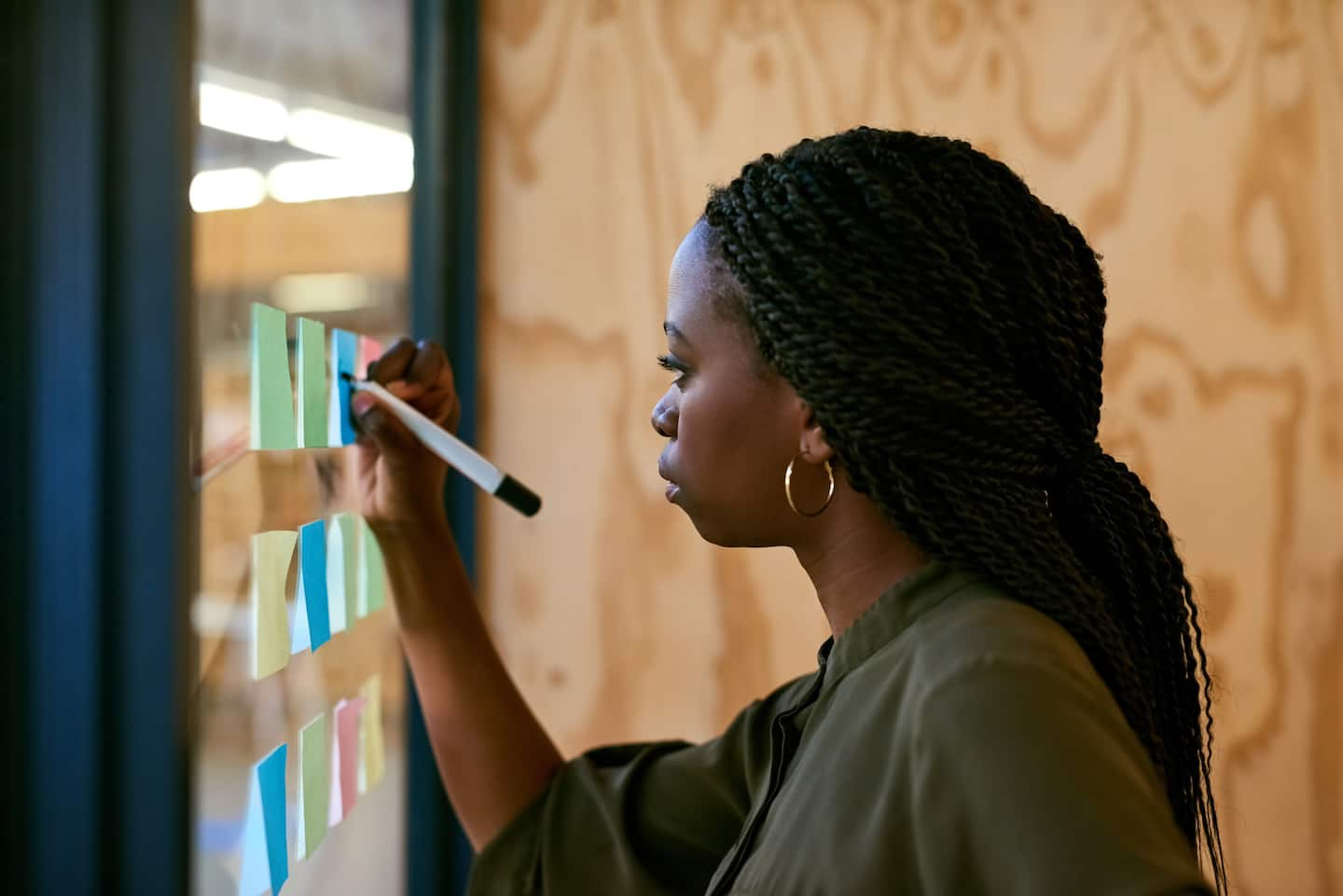 A young designer writing on adhesive notes.