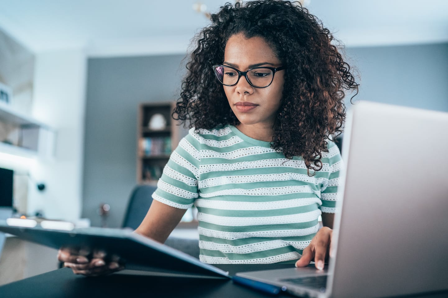 Young woman in glasses using laptop and tablet