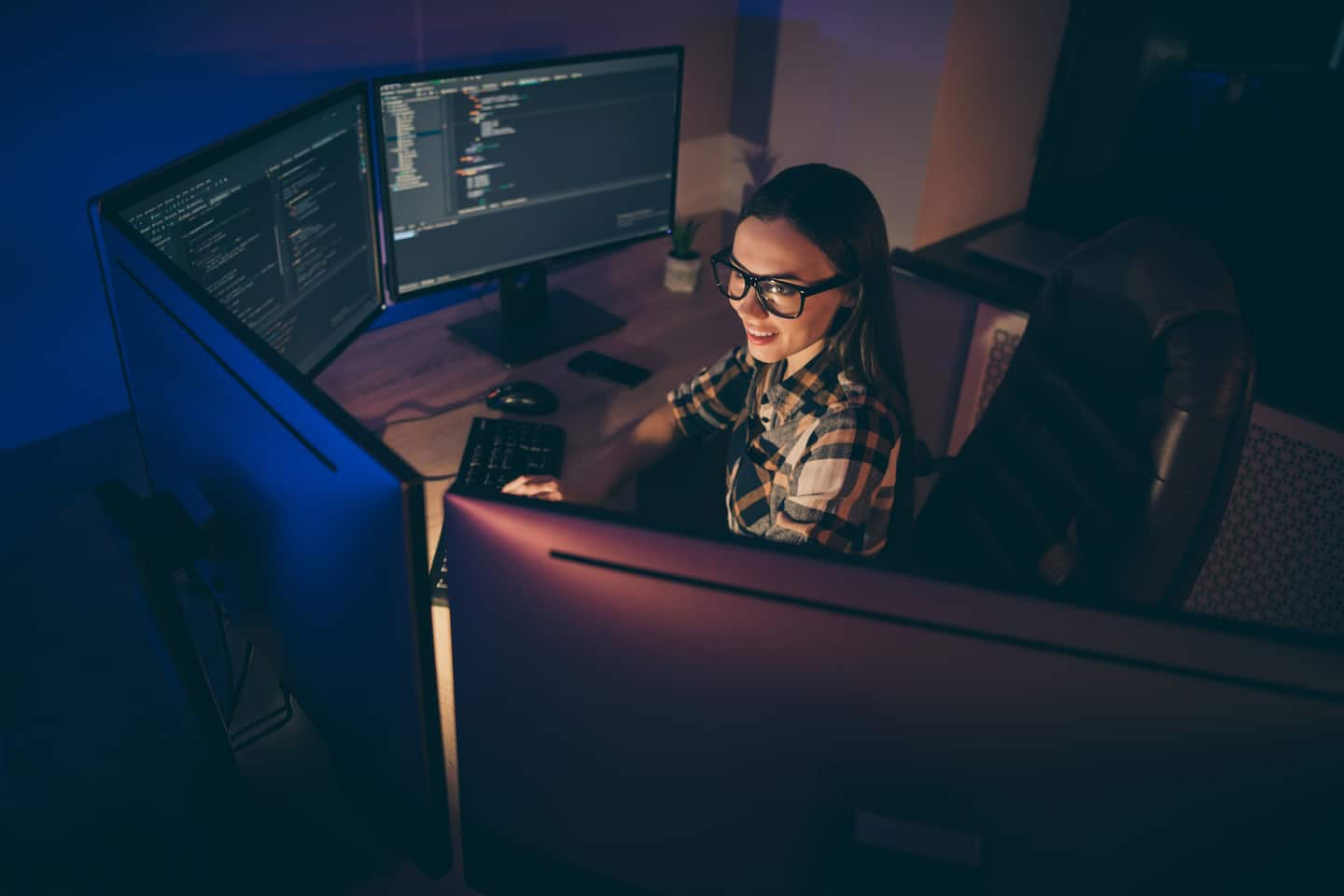 Top angle view of cheerful girl in spectacles working as an I.T. specialist.