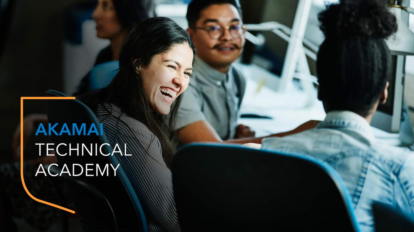 Image of three students sitting at a desk with computers looking focused but happy. There is an Akamai Technical Academy brand mark on the image.